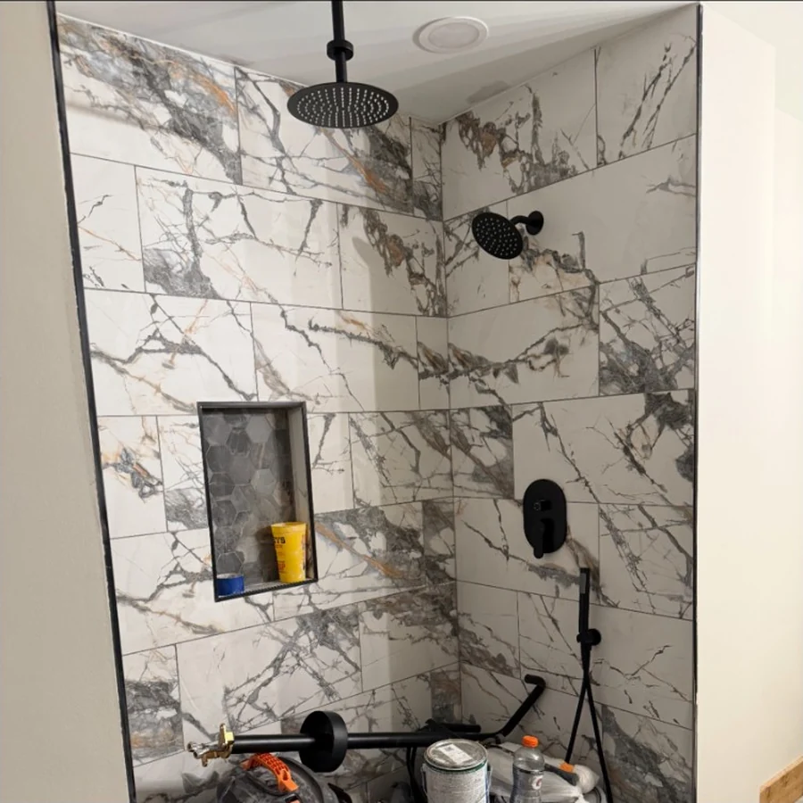 Marble-look tiled shower with matte black fixtures
