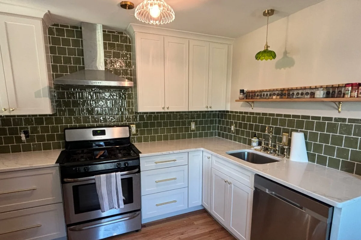 Finished kitchen remodel with white cabinets and green tile backsplash